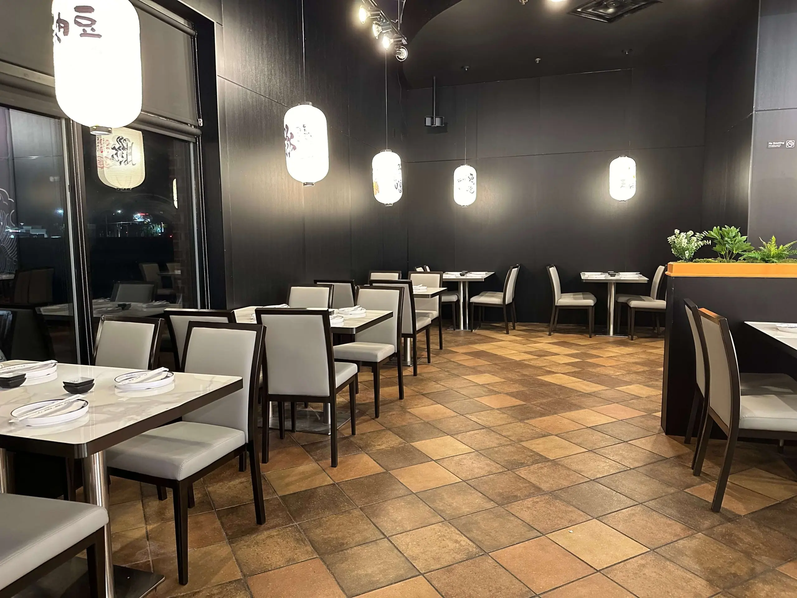 Stylish dining area with dark walls and Japanese lanterns at Sushi Kingdom, a Japanese Restaurant in Savannah